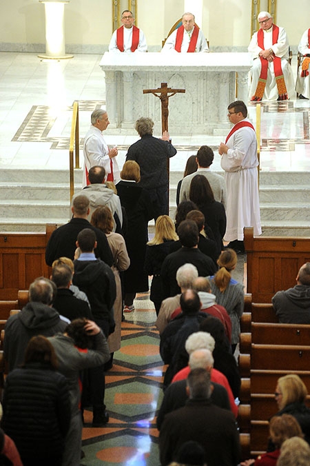 Parishioners line up to kiss the feet of Jesus on the Cross shortly after the Veneration during the Solemn Celebration of the Lord's Passion at St. Joseph Cathedral. (Dan Cappellazzo/Staff Photographer)